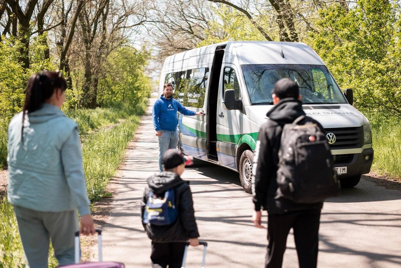 Родина сідає в мікроавтобус AlexTransfer з валізами