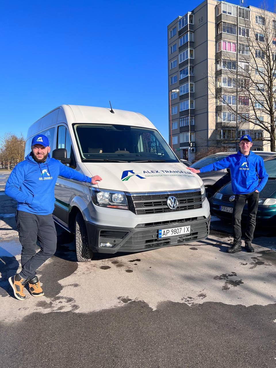 Два водії AlexTransfer у фірмових худі біля мікроавтобуса